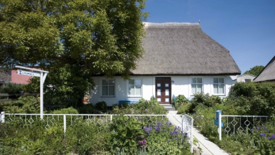 Gemütlich übernachten in Schillings Gästehaus in Schaprode auf der Insel Rügen, einem weißen mit Reetdach gedeckten Haus.