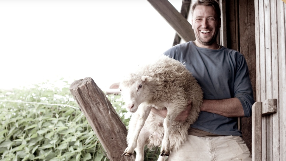 Landwirt & Gastronom Mathias Schilling mit einem Schaf unter dem Arm