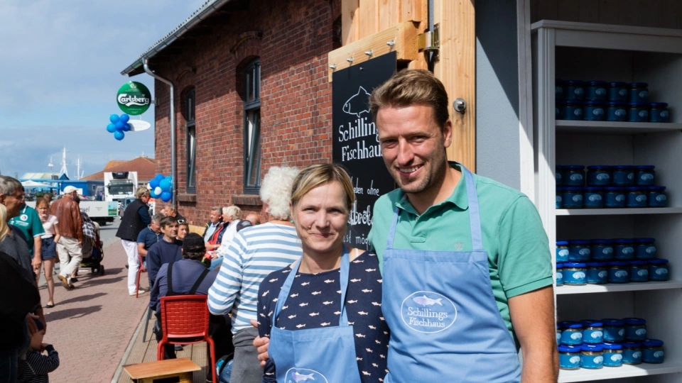 Zu sehen ist das Eingangsschild von Schillings Fischhaus in Schaprode, ein Schild mit einem ausgeschnittenen Fisch in braunem Metall.